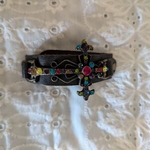 Rhinestone cross mounted on brown leather band